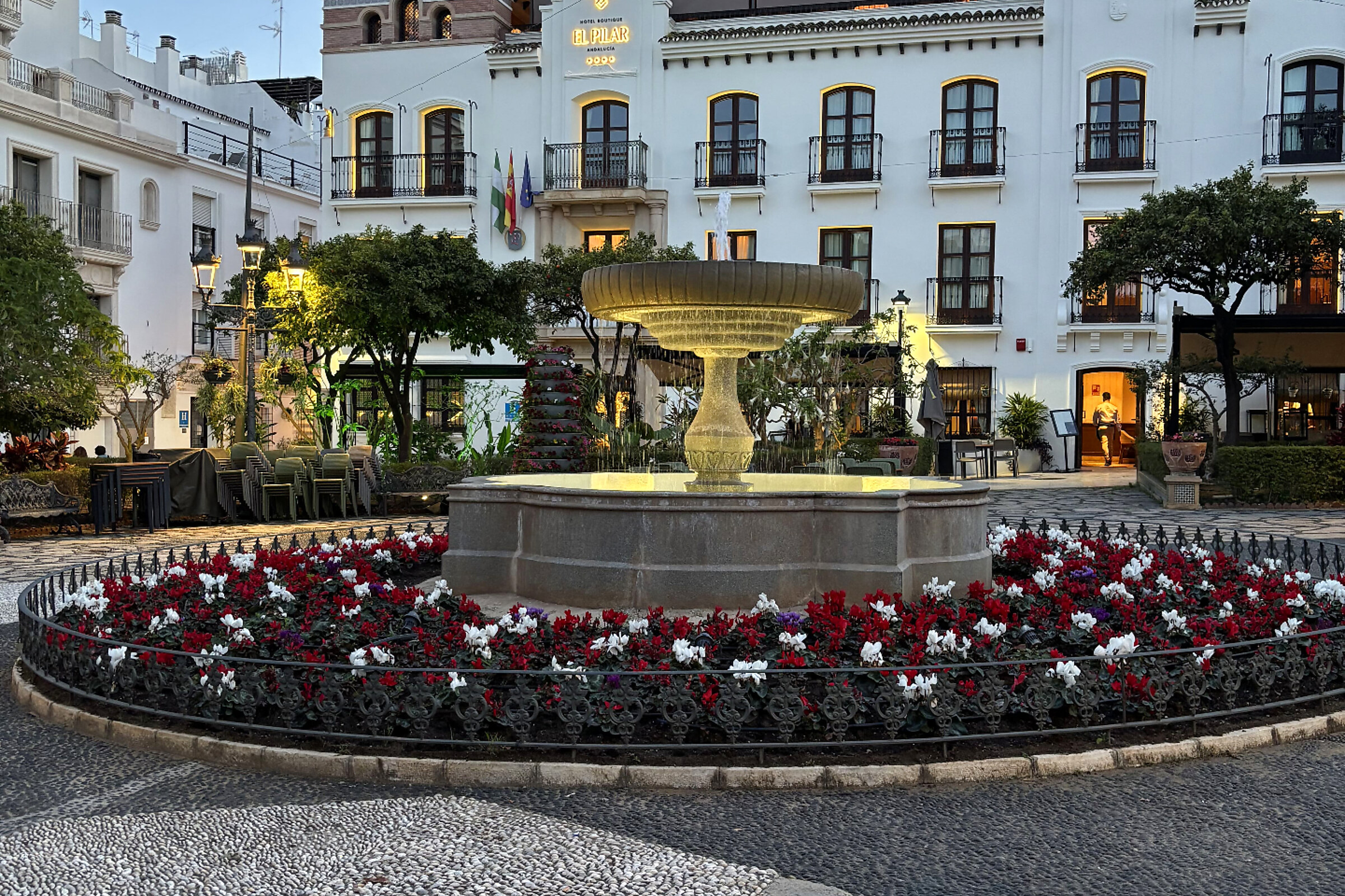 Brunnen mit Blumenrabatten auf der Plaza de las Flores in Estepona bei Abendlicht