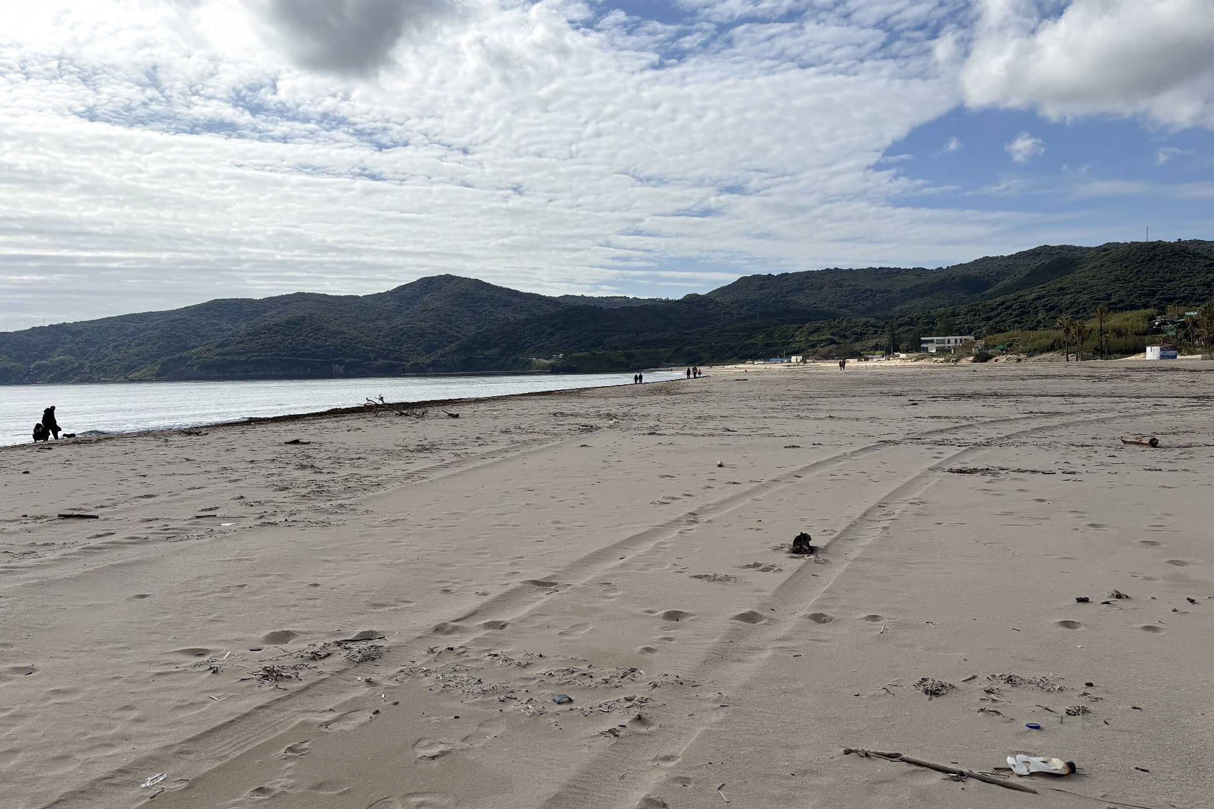 Weitläufiger Sandstrand Playa de Getares in Algeciras mit grünen Hügeln im Hintergrund