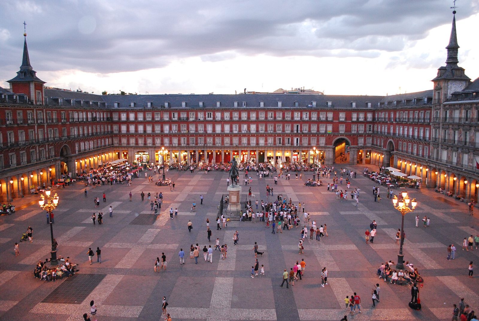 Plaza Mayor in Madrid mit Arkaden, Reiterstandbild und Menschen am frühen Abend