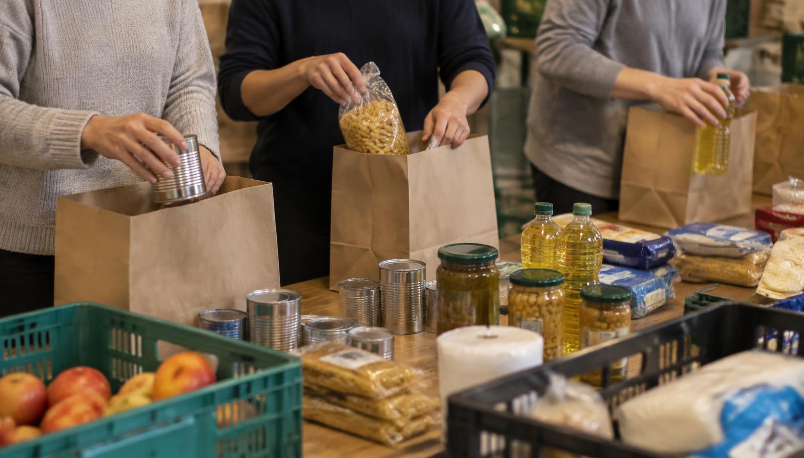 Freiwillige packen Lebensmitteltüten bei einer Tafel