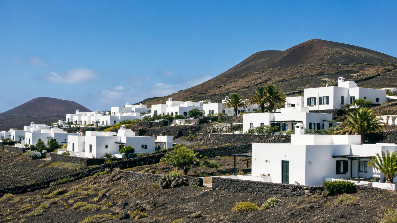 Weiße Wohnhäuser an einem Hang auf Lanzarote (KI-generierte Illustration)