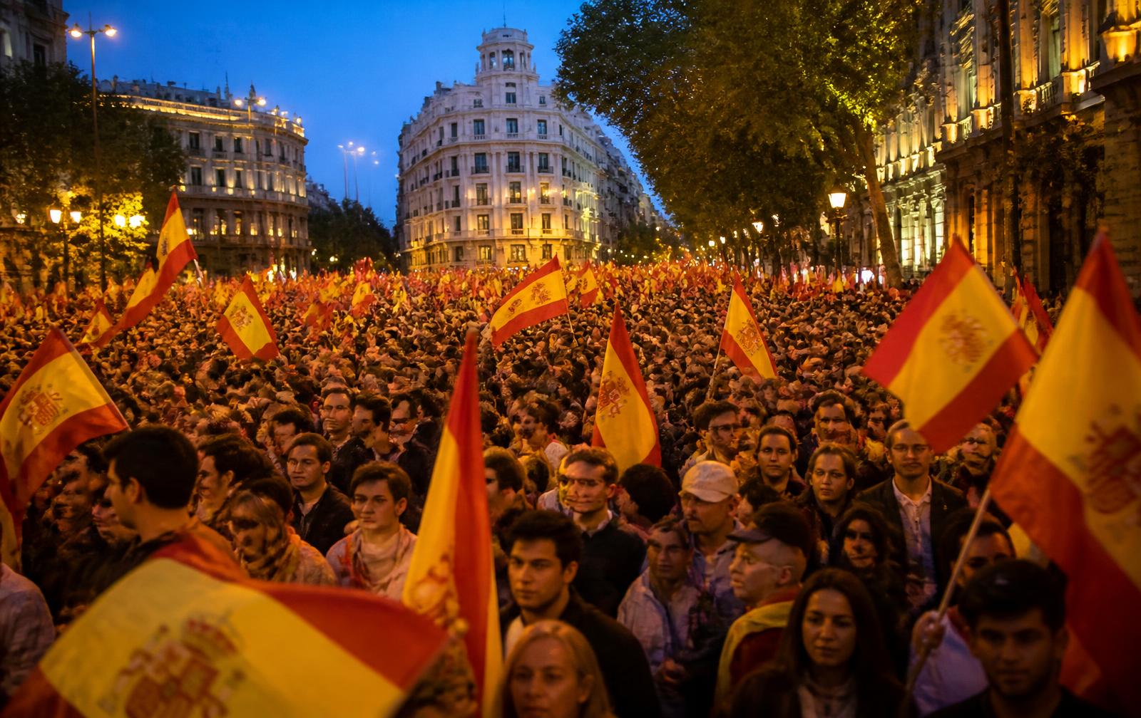 Große Abenddemonstration mit spanischen Flaggen auf einem Boulevard in Madrid