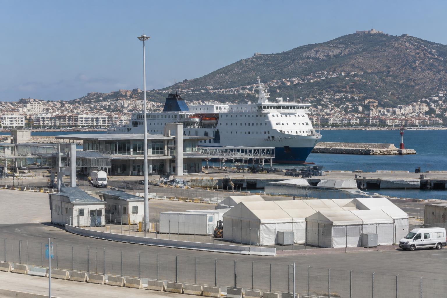 Hafen von Ceuta bei Tageslicht mit Fährschiff, Hafeninfrastruktur und provisorischen Zelten