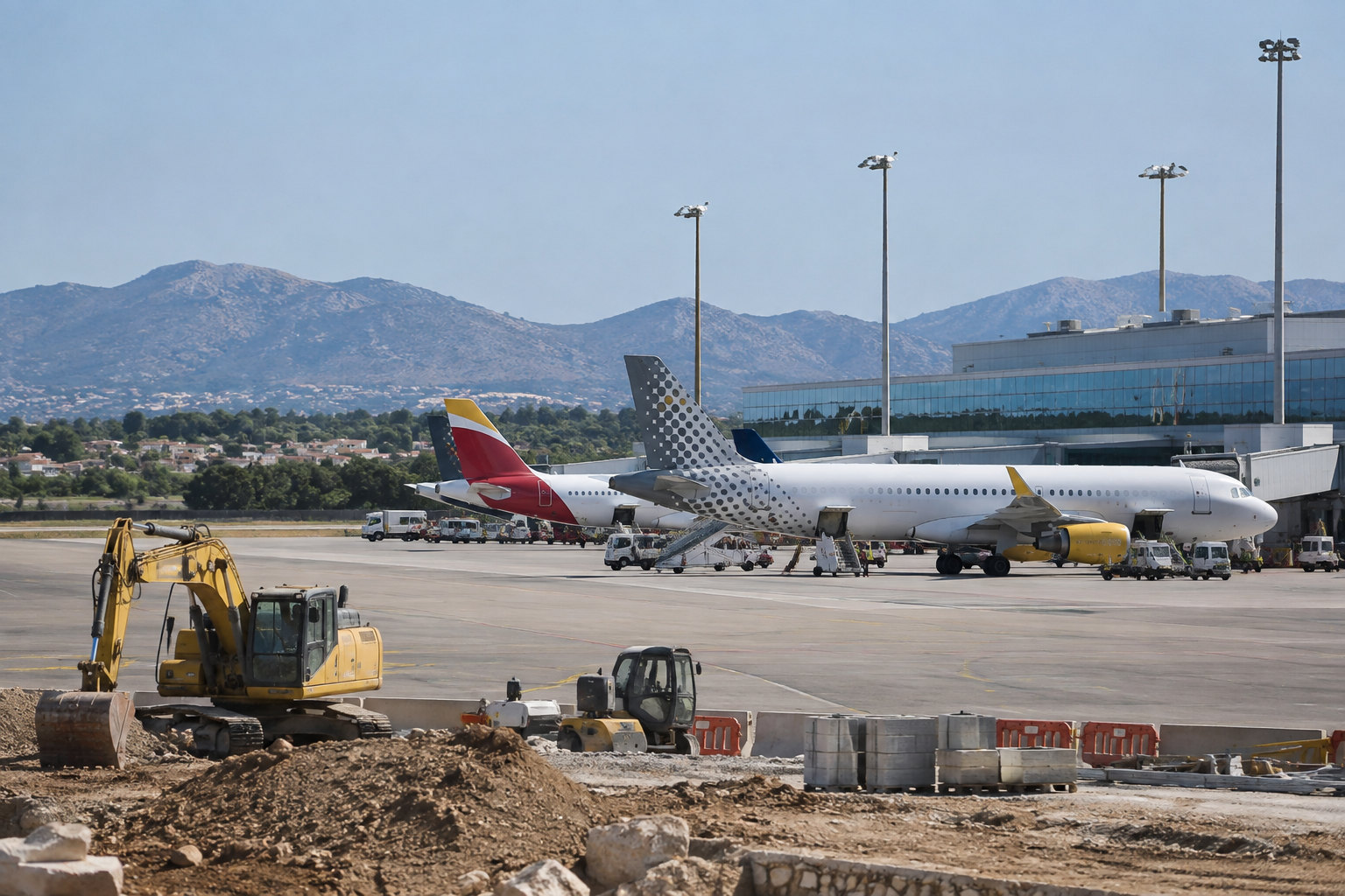 Vorfeld eines Balearen-Flughafens mit Passagiermaschinen, Terminal und Baugerät unter mediterranem Himmel