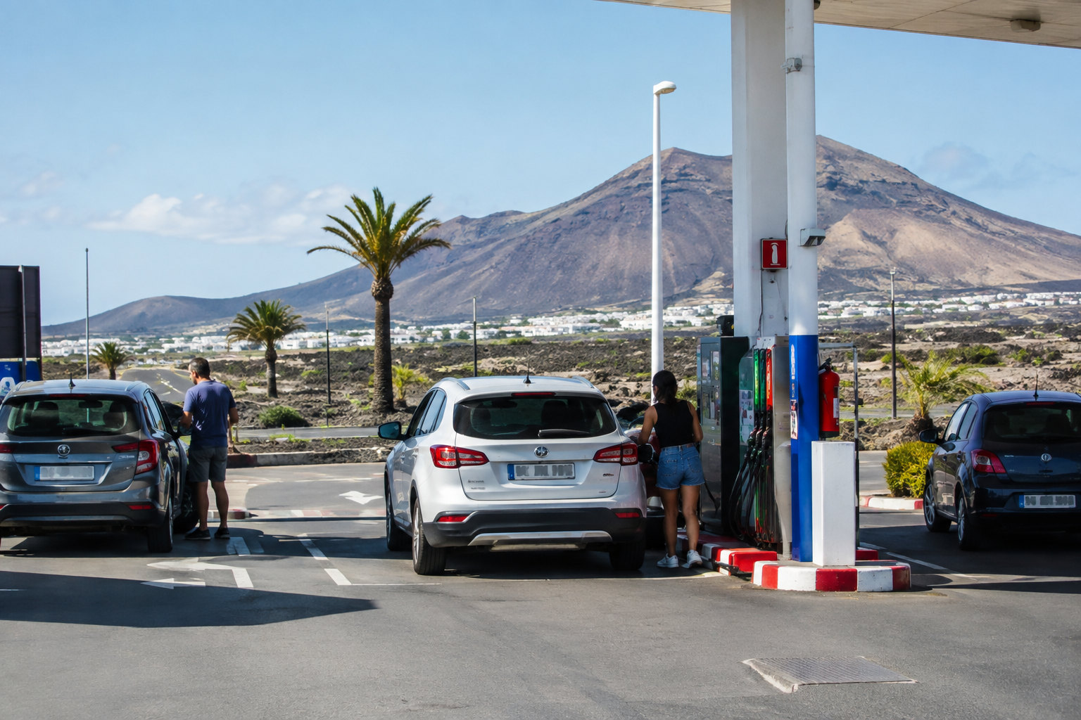 Tankstelle auf den Kanaren mit Autos an den Zapfsäulen vor vulkanischer Insellandschaft