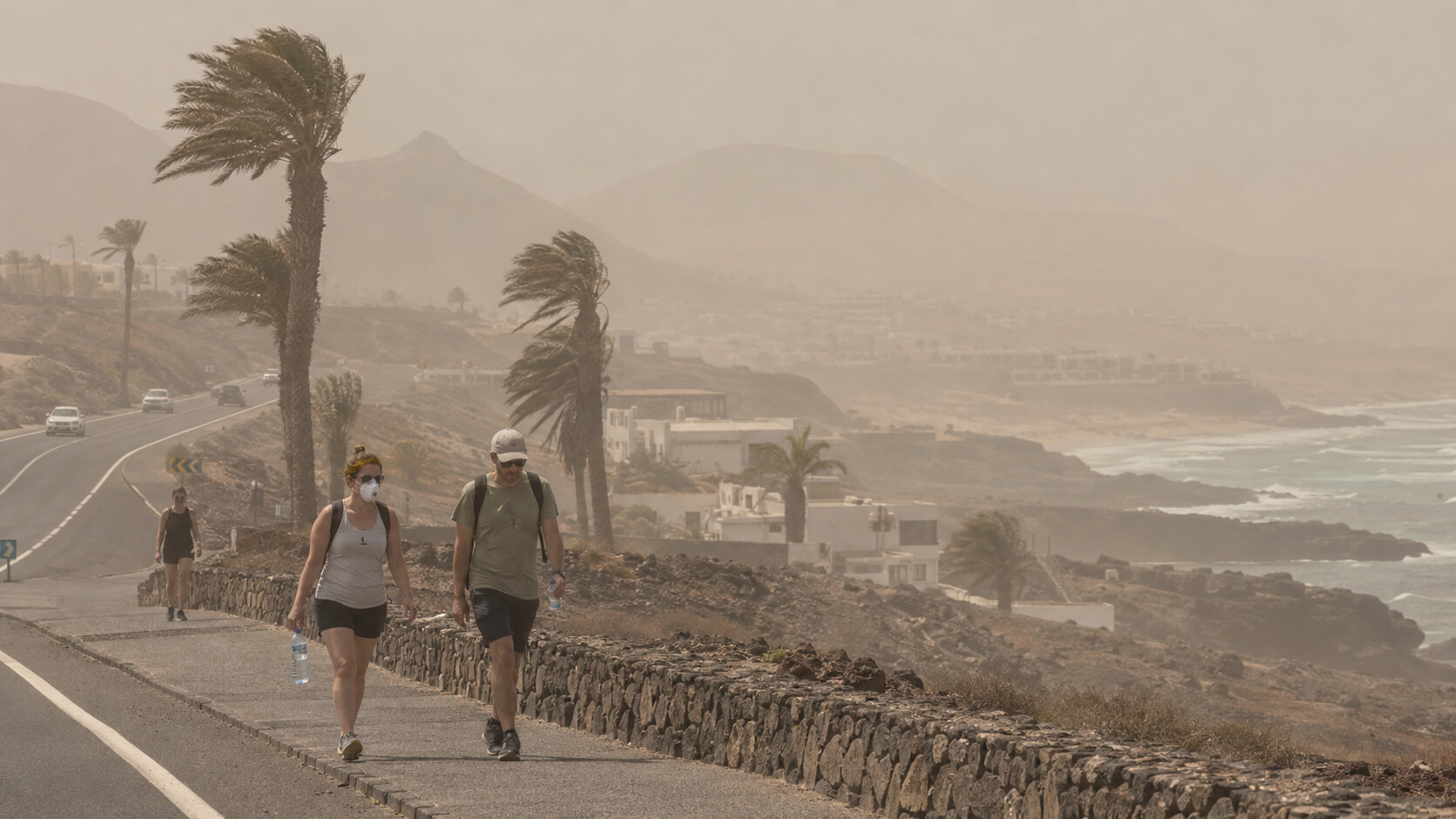 Wanderer auf einer Küstenstraße auf Fuerteventura bei dichter Calima.