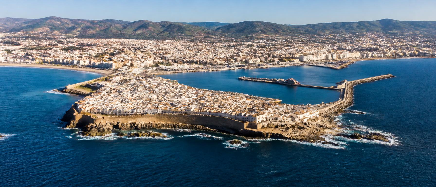 Luftaufnahme der türkisfarbenen Meerenge vor der felsigen Küste von Ceuta in der Abenddämmerung